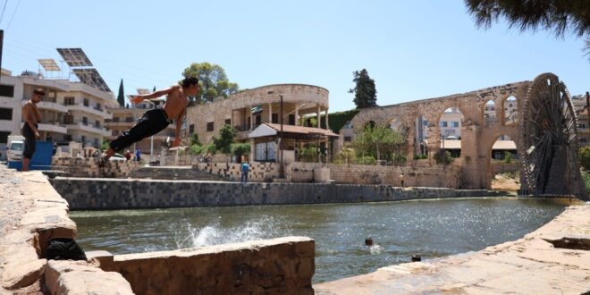 Niños sirios juegan en las norias en el río Orontes